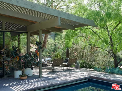a view of backyard with a table and chairs under an umbrella