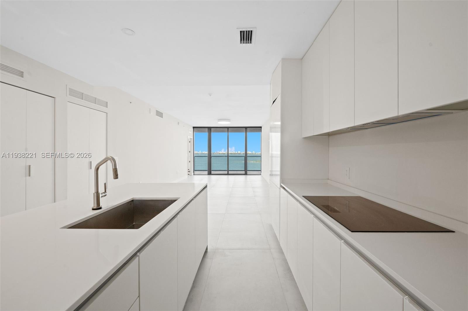 700 Northeast 24th Street, Unit 1406 Miami, FL 33137 - Photo 12 of 55 a kitchen with a sink cabinets and a stove