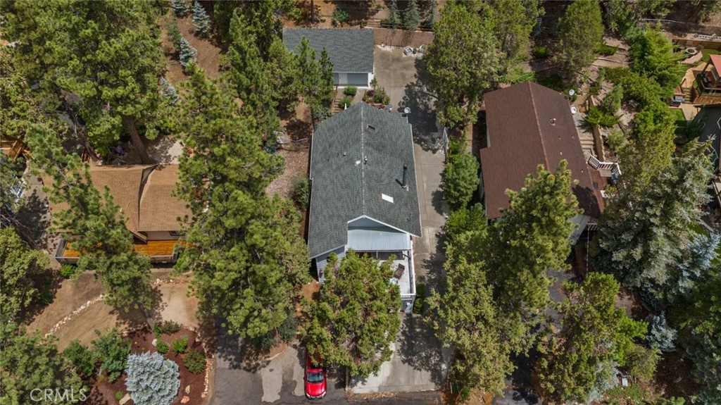 an aerial view of a house with a yard and trees all around