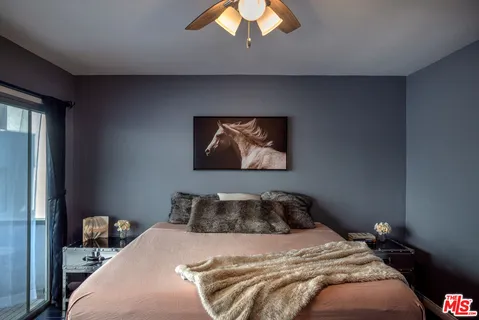 a bedroom with a bed and a painting on the wall
