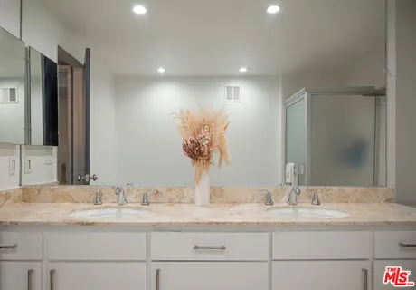 a bathroom with double vanity sinks and a mirror