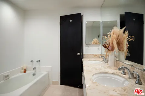 a bathroom with a tub sink and mirror