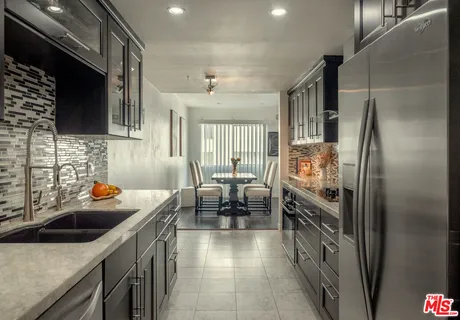 a kitchen with sink refrigerator and cabinets