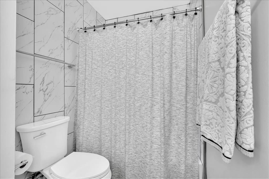 2 Milam Street Cartersville, GA 30120 - Photo 31 of 57 a white toilet sitting next to a shower curtain