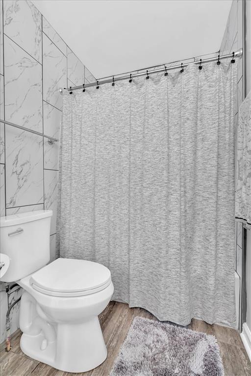 2 Milam Street Cartersville, GA 30120 - Photo 32 of 57 a white toilet sitting next to a shower curtain