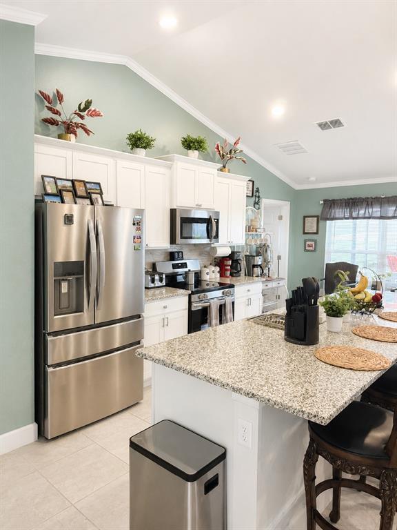 5892 Southwest 82nd Lane Ocala, FL 34476 - Photo 5 of 24 a kitchen with granite countertop a refrigerator a stove a sink a dining table and chairs with wooden floor