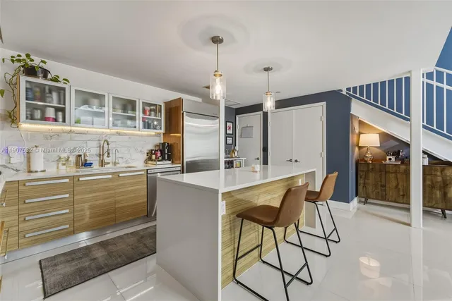 a kitchen with granite countertop white cabinets and stainless steel appliances