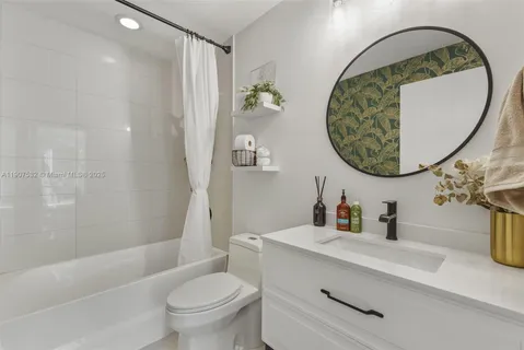 a bathroom with a sink a mirror a toilet and a bathtub