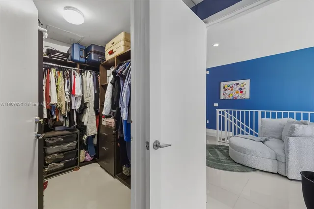 a view of walk in closet with clothes and shoes