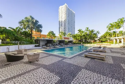 a swimming pool with outdoor seating and yard in the back