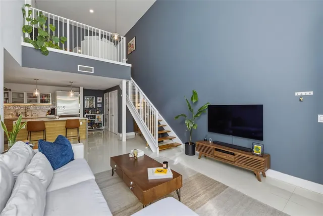 a living room with furniture flat screen tv and a potted plant