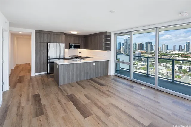 a kitchen with kitchen island wooden floors and stainless steel appliances