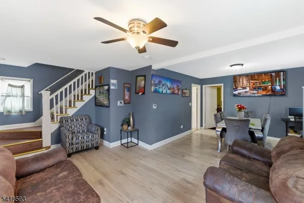 a living room with furniture ceiling fan and a window