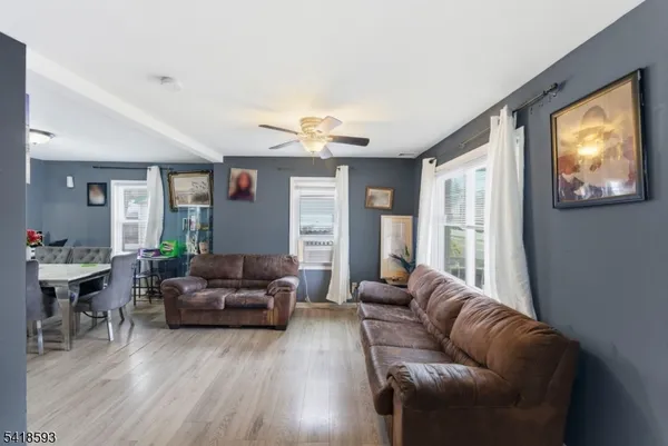 a living room with furniture ceiling fan and a window