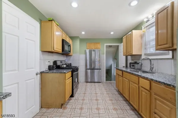a kitchen with stainless steel appliances granite countertop a sink counter space cabinets and a large window