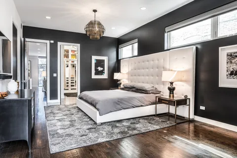 a bedroom with a large bed and a chandelier