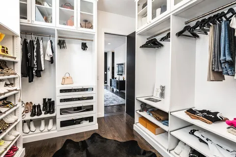 a view of walk in closet with clothes and shoes