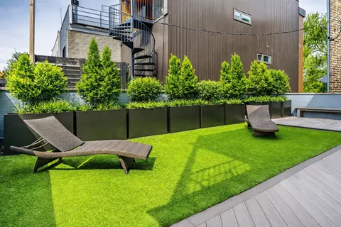 a view of a chair and table in back yard of the house