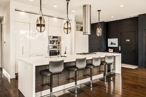 a kitchen with a table chairs refrigerator and microwave