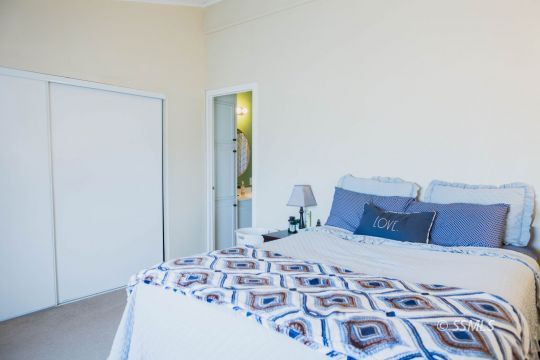 1140 North Calvert Boulevard Ridgecrest, CA 93555 - Photo 20 of 27 a bedroom with a large bed and a chandelier