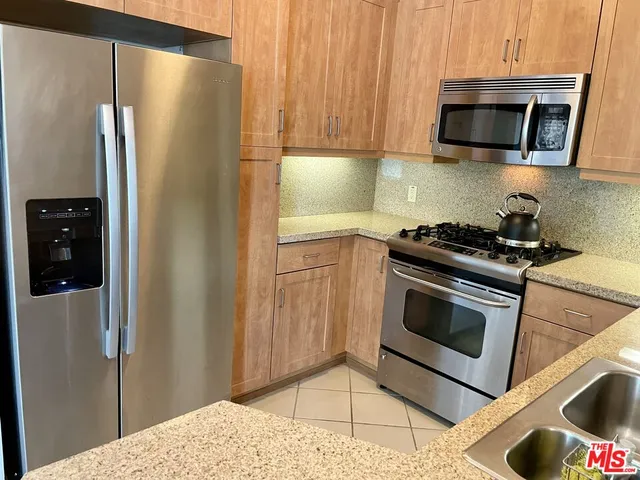 a kitchen with stainless steel appliances granite countertop a refrigerator stove and microwave