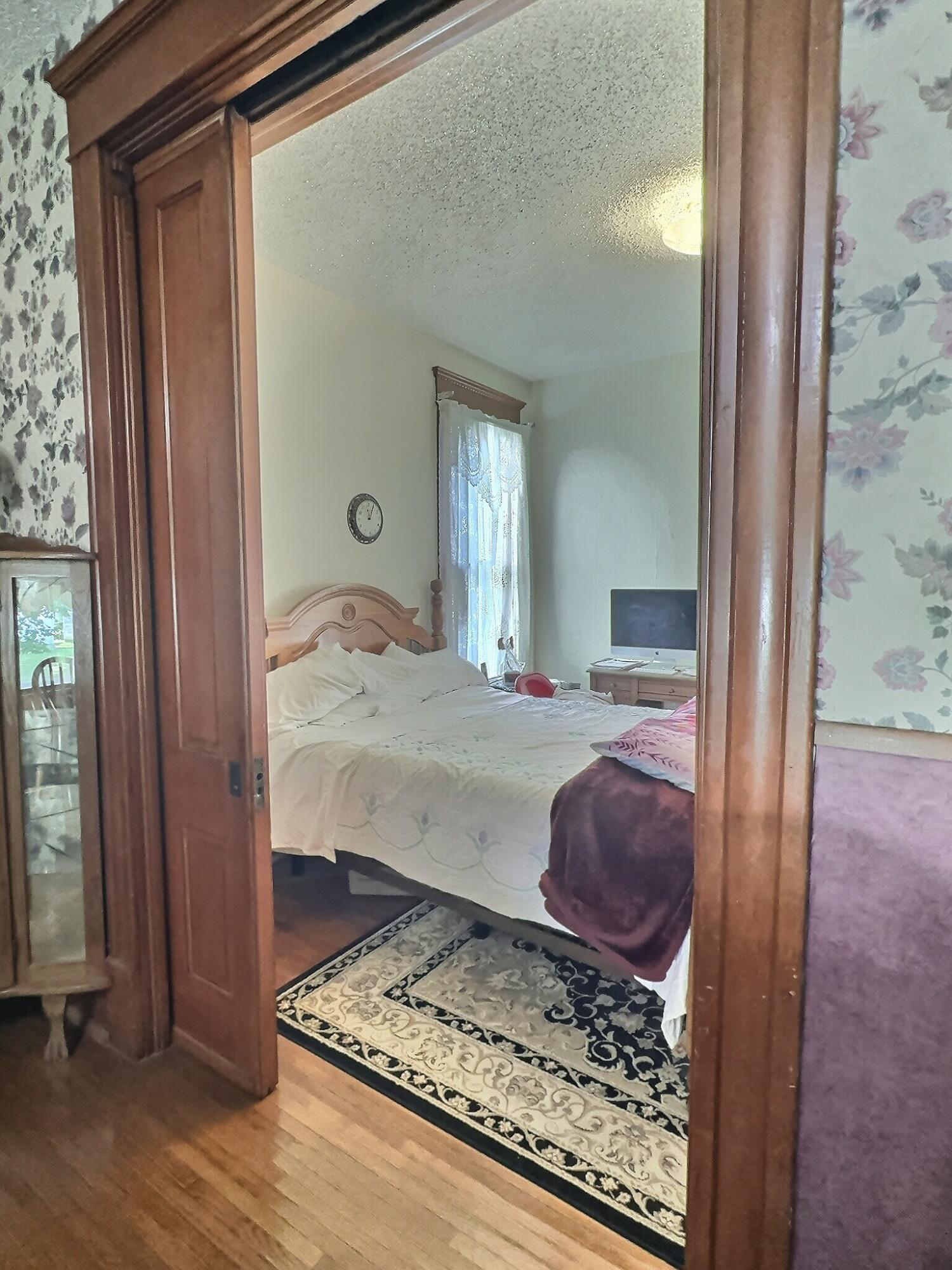 136 East Main Street Brook, IN 47922 - Photo 9 of 25 a bedroom with a bed and wooden floor