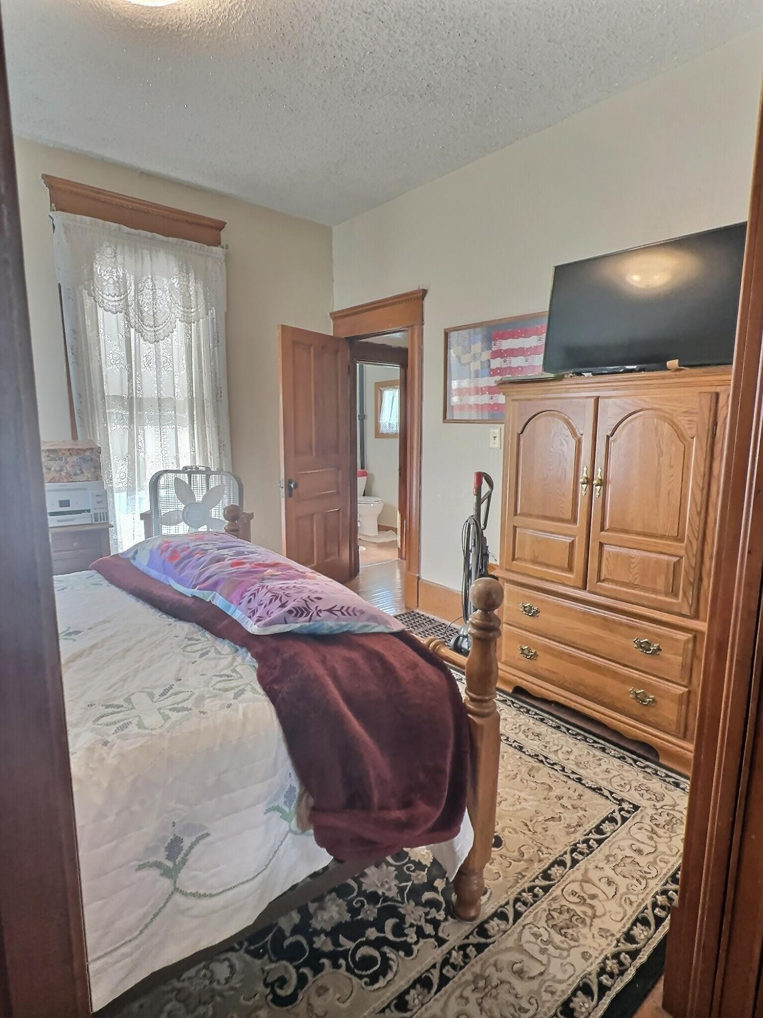 136 East Main Street Brook, IN 47922 - Photo 10 of 25 a bedroom with a bed and wooden floor