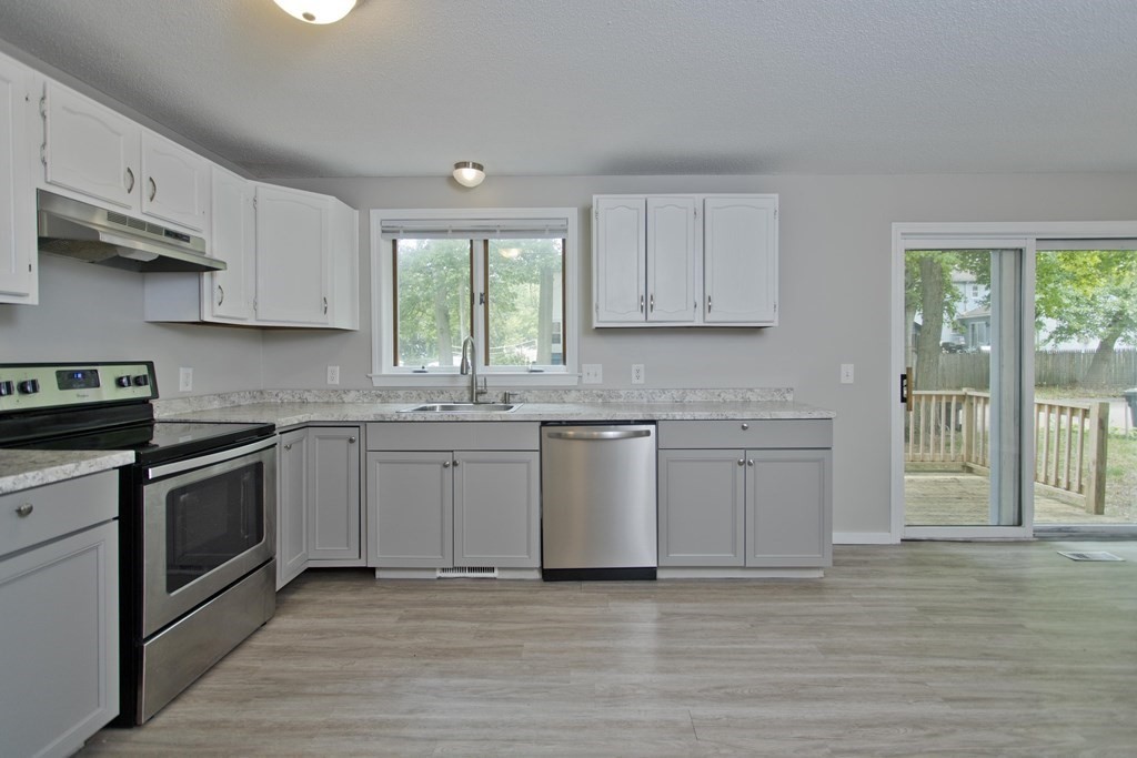108 Odion Avenue Springfield, MA 01118 - Photo 3 of 24 a kitchen with granite countertop white cabinets stainless steel appliances a sink and a window