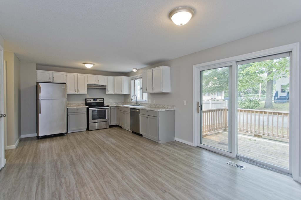 108 Odion Avenue Springfield, MA 01118 - Photo 4 of 24 a kitchen with white cabinets and stainless steel appliances
