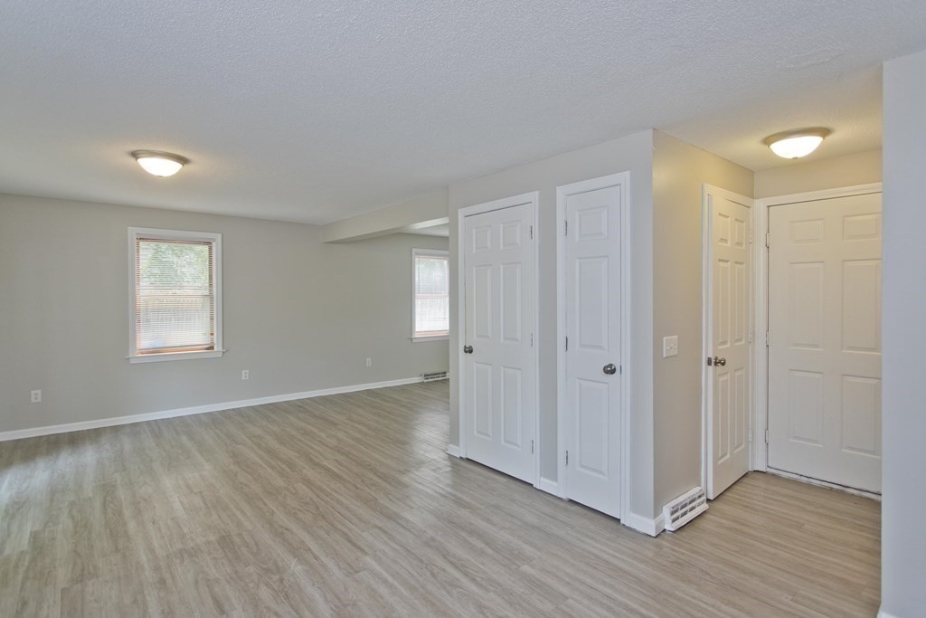 108 Odion Avenue Springfield, MA 01118 - Photo 6 of 24 an empty room with wooden floor and windows