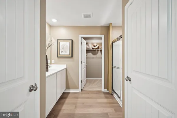 a view of a hallway with bathroom and wooden floor