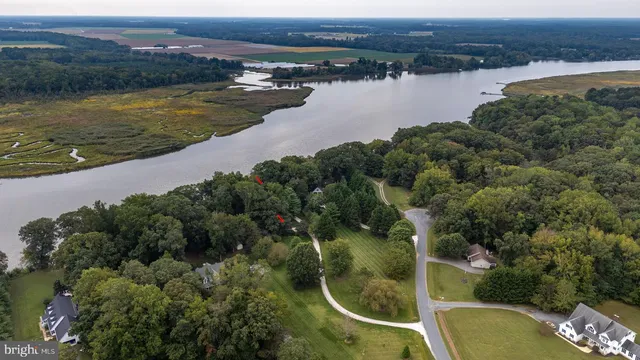 an aerial view of a house with a yard and lake view