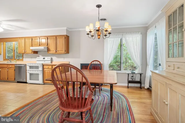 a dining room with furniture a chandelier and wooden floor