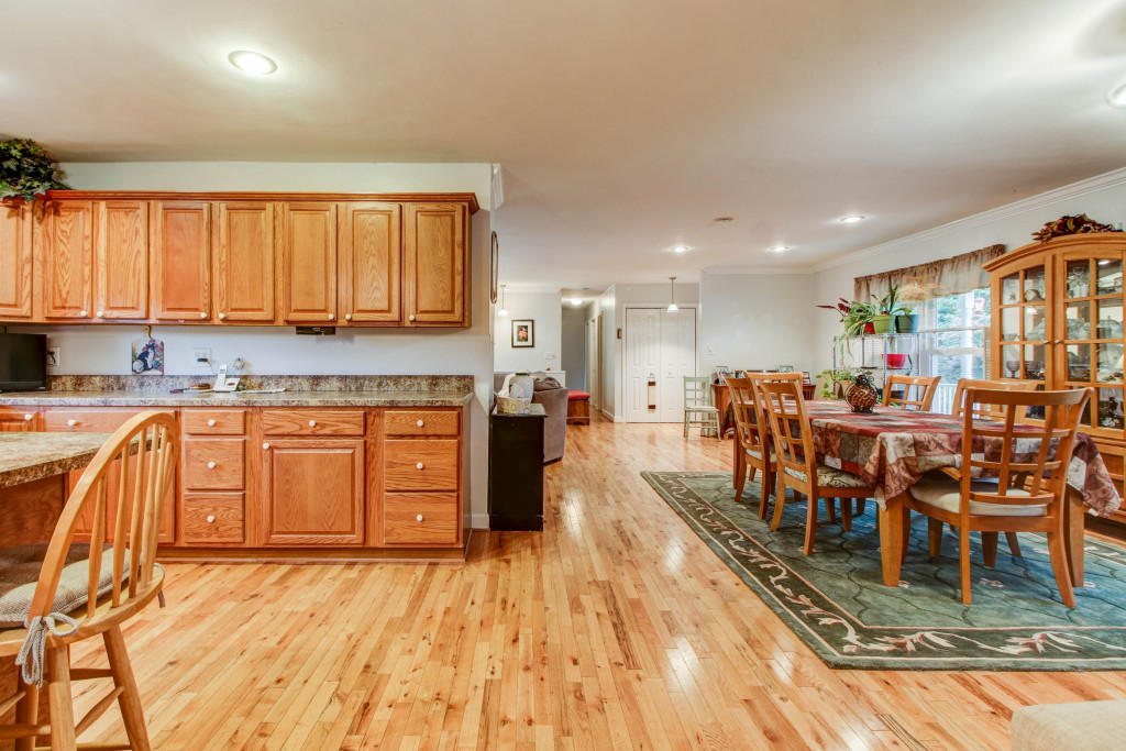 1400 Morgans Mill Road Goodview, VA 24095 - Photo 11 of 21 a kitchen with stainless steel appliances granite countertop a stove top oven a sink a dining table and chairs with wooden floor