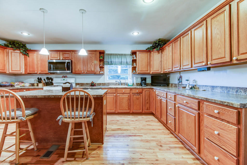 1400 Morgans Mill Road Goodview, VA 24095 - Photo 8 of 21 a kitchen with stainless steel appliances granite countertop a sink a stove a refrigerator cabinets and a dining table