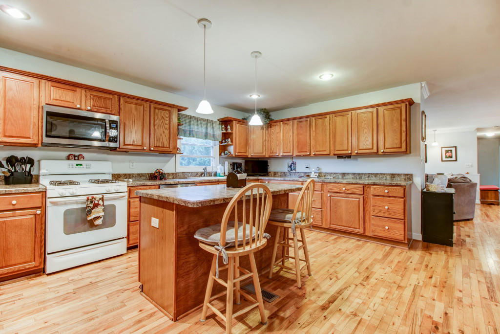 1400 Morgans Mill Road Goodview, VA 24095 - Photo 9 of 21 a kitchen with stainless steel appliances kitchen island granite countertop a stove a sink a microwave and a refrigerator