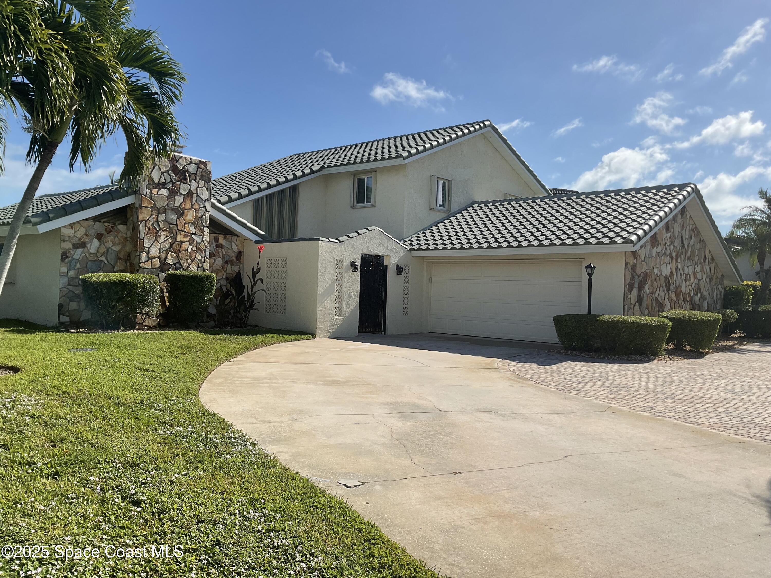 215 Andros Avenue Cocoa Beach, FL 32931 - Photo 1 of 55 a front view of a house with a yard and garage