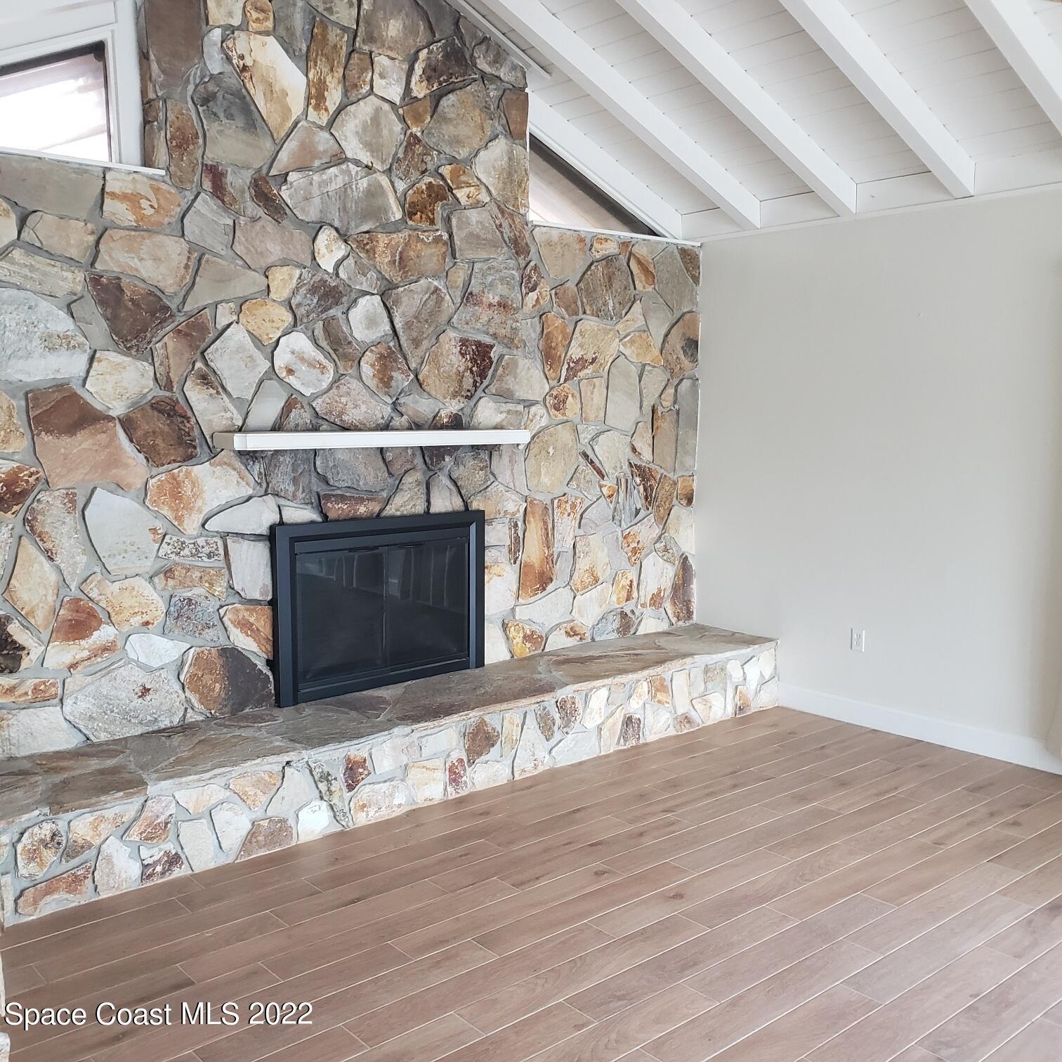 215 Andros Avenue Cocoa Beach, FL 32931 - Photo 15 of 55 a view of wooden floor with a fireplace
