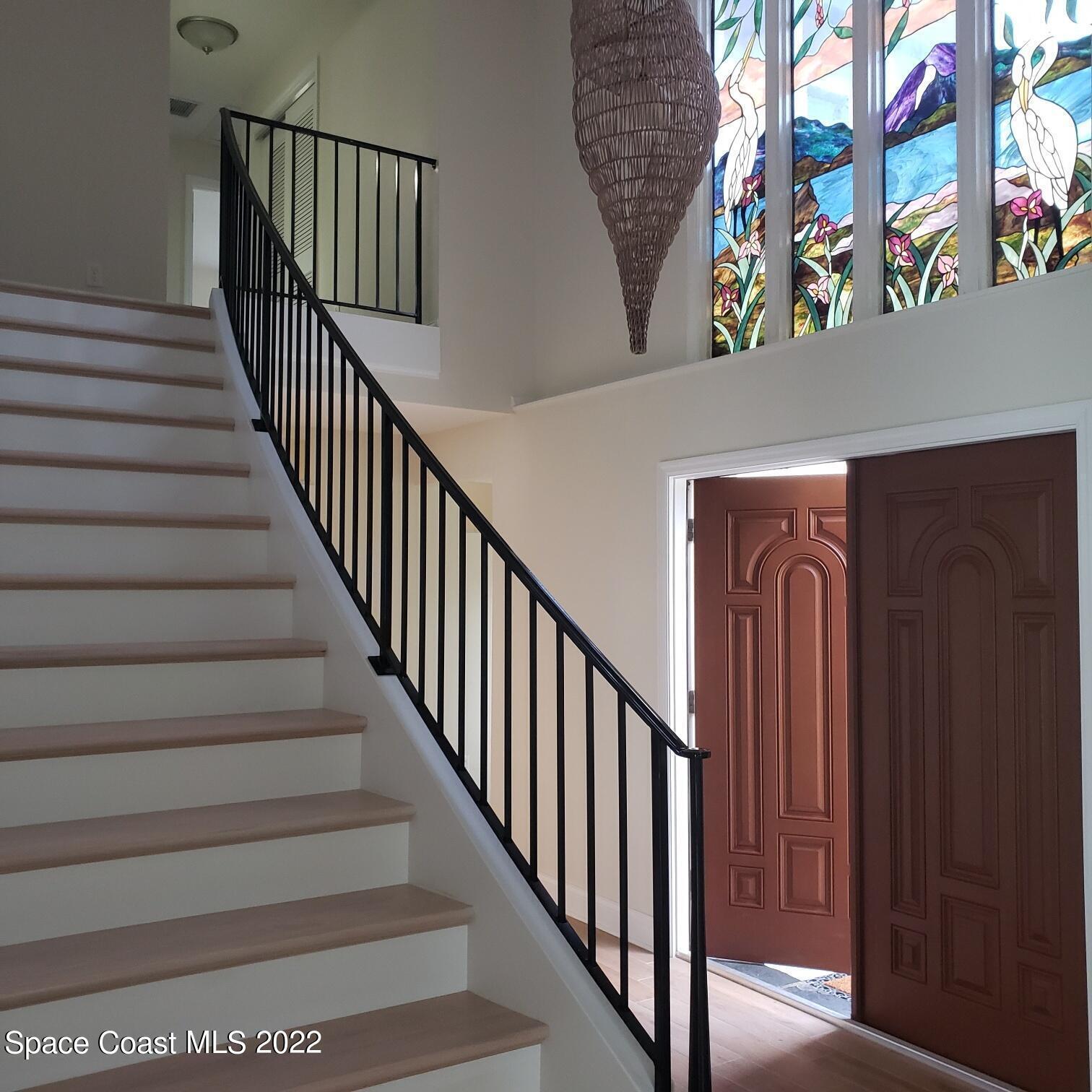 215 Andros Avenue Cocoa Beach, FL 32931 - Photo 17 of 55 a view of staircase with railing and a chandelier