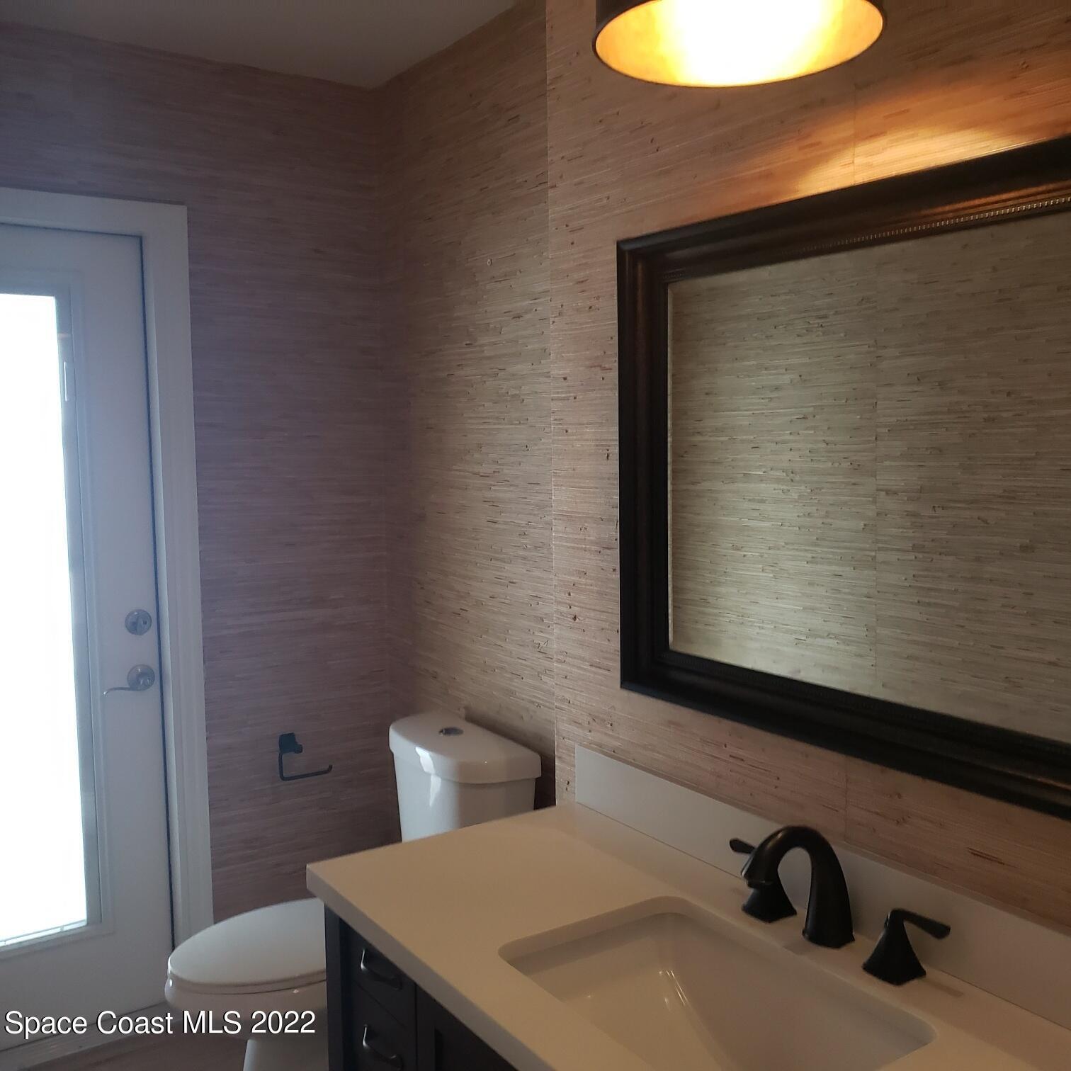 215 Andros Avenue Cocoa Beach, FL 32931 - Photo 18 of 55 a bathroom with a sink and a mirror