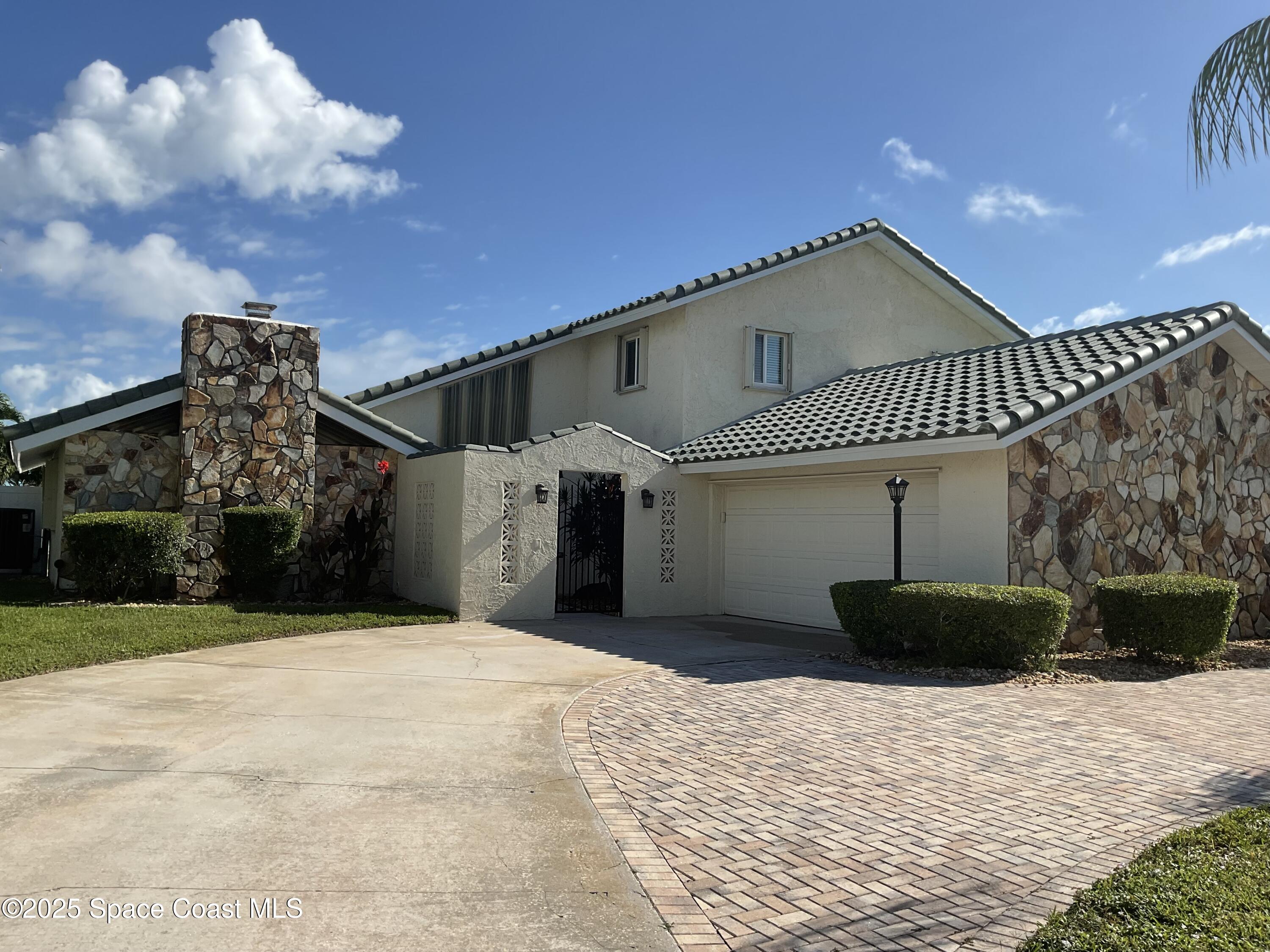 215 Andros Avenue Cocoa Beach, FL 32931 - Photo 2 of 55 a front view of a house with a yard
