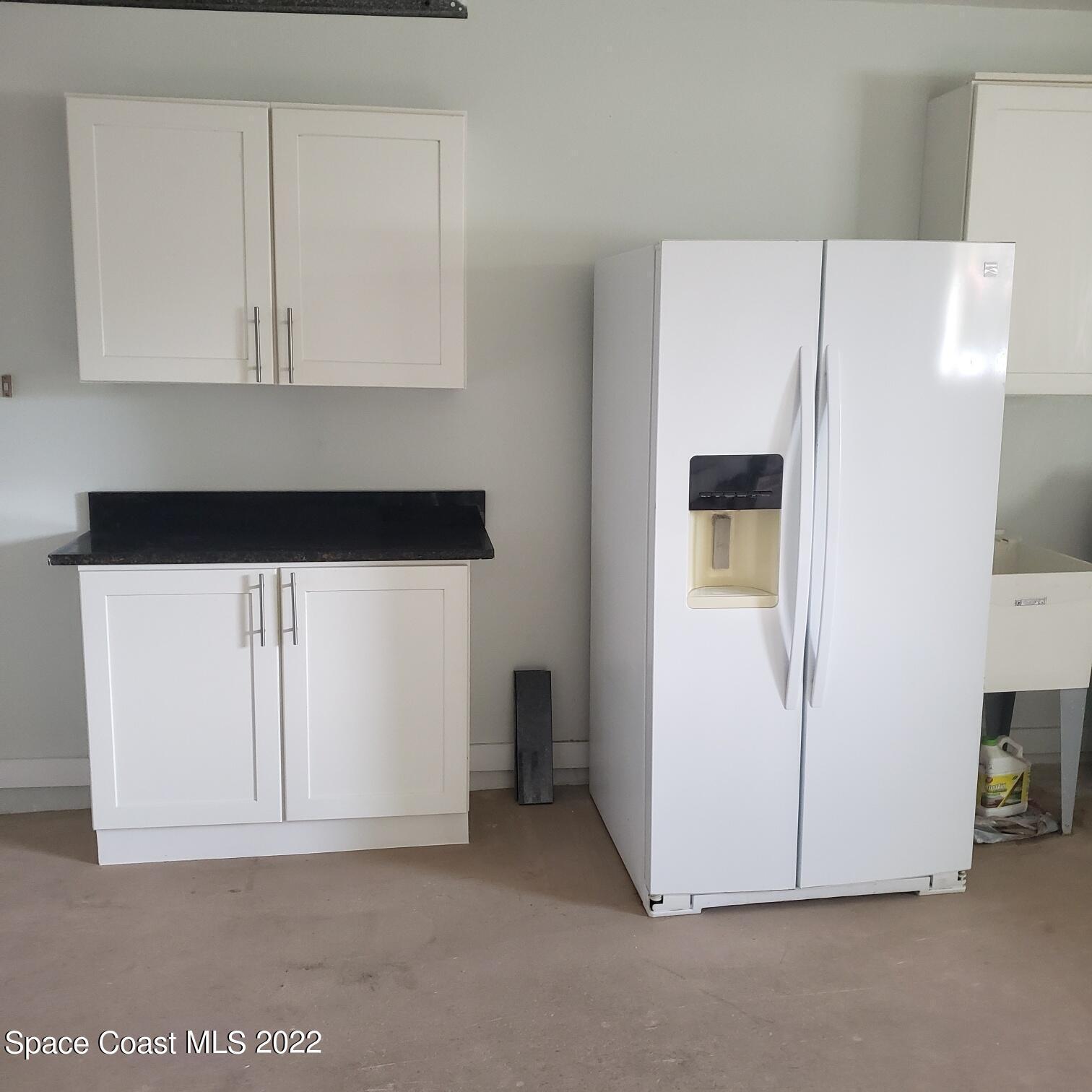 215 Andros Avenue Cocoa Beach, FL 32931 - Photo 21 of 55 a kitchen with a white cabinets and white appliances