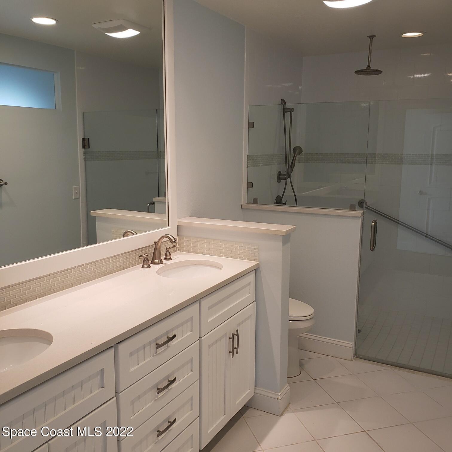 215 Andros Avenue Cocoa Beach, FL 32931 - Photo 22 of 55 a bathroom with a sink a toilet and shower