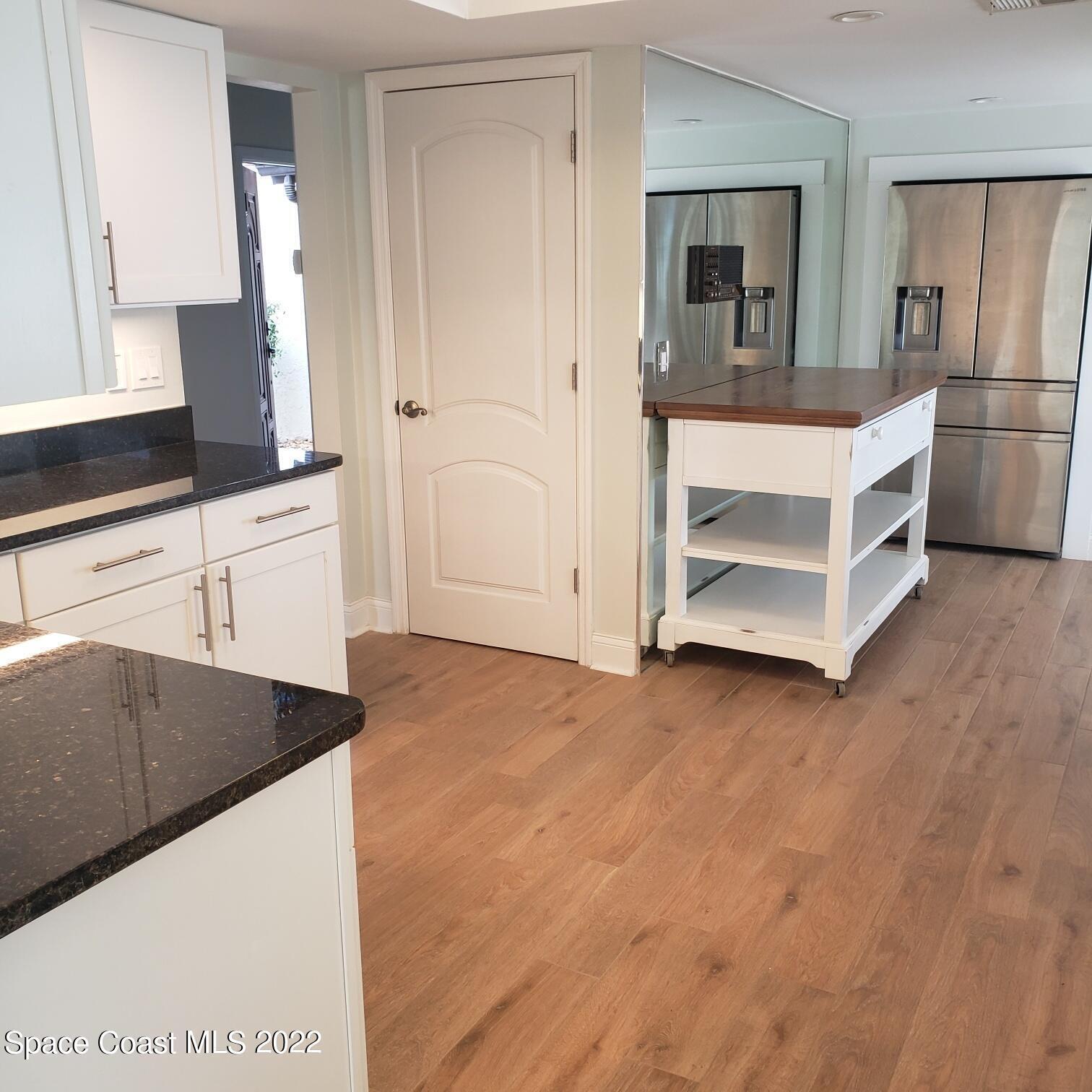 215 Andros Avenue Cocoa Beach, FL 32931 - Photo 27 of 55 a kitchen with stainless steel appliances cabinets and wooden floor