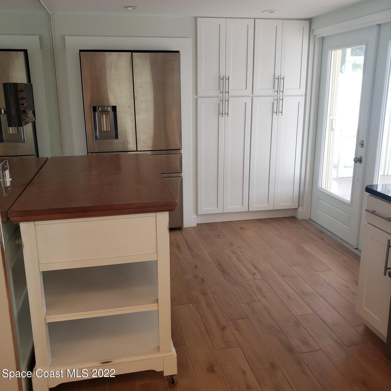 215 Andros Avenue Cocoa Beach, FL 32931 - Photo 28 of 55 a view of a hallway with wooden floor and cabinet