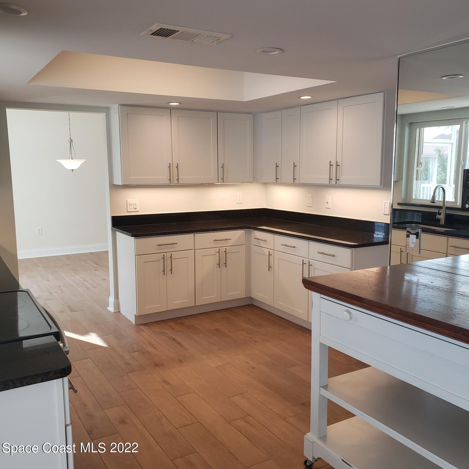 215 Andros Avenue Cocoa Beach, FL 32931 - Photo 29 of 55 a kitchen with granite countertop a sink and cabinets