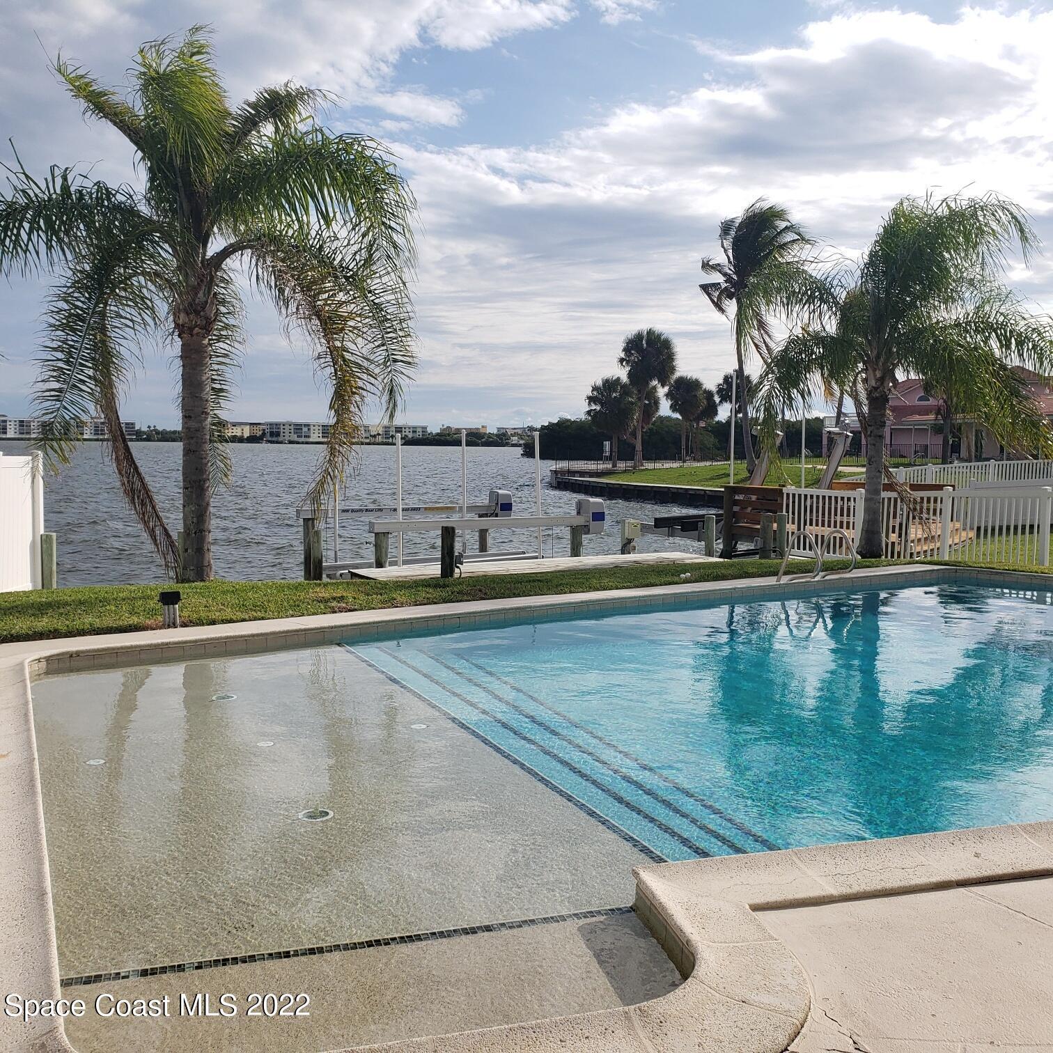 215 Andros Avenue Cocoa Beach, FL 32931 - Photo 34 of 55 a view of swimming pool with a table and chairs