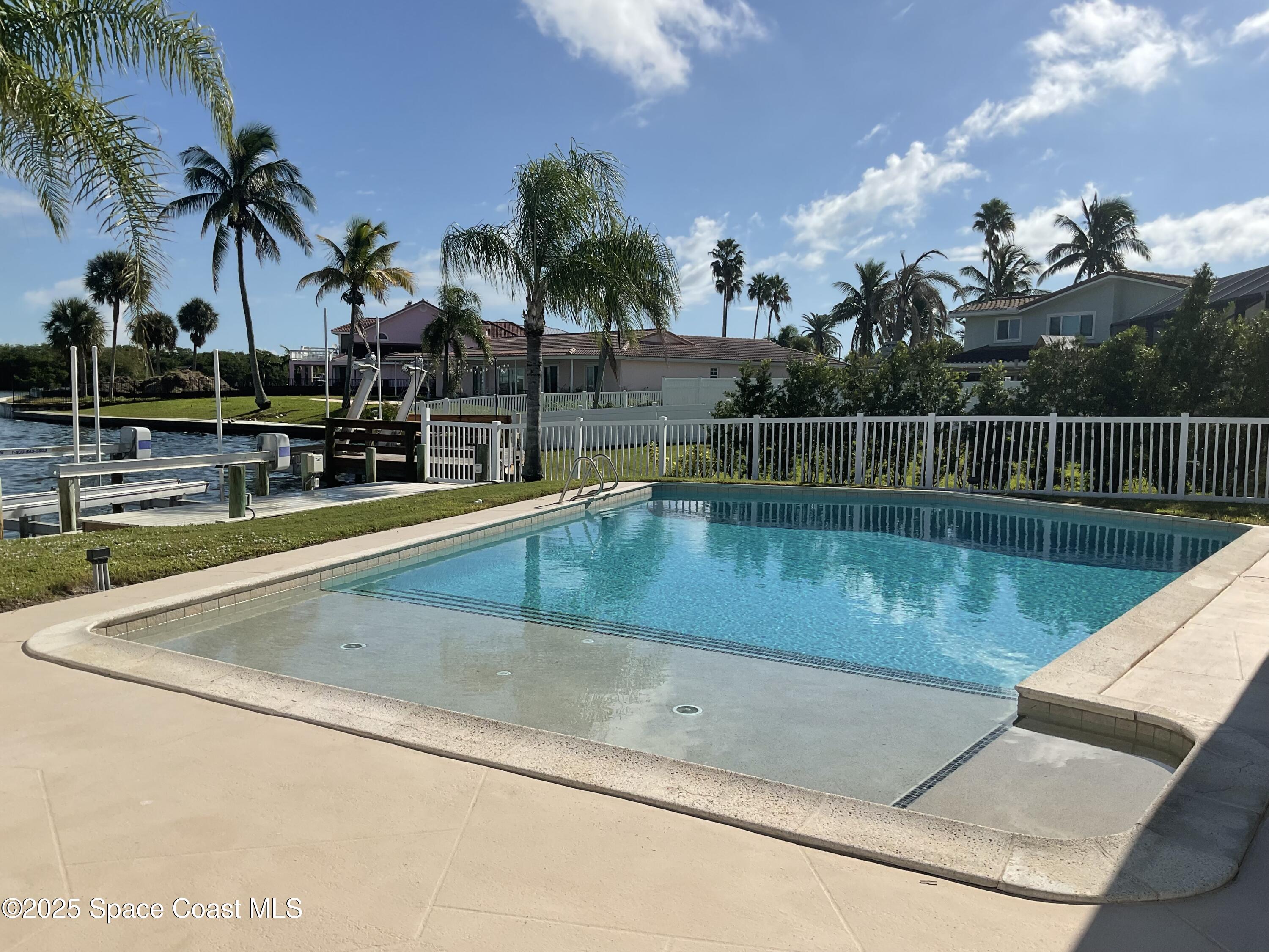 215 Andros Avenue Cocoa Beach, FL 32931 - Photo 50 of 53 a view of swimming pool with a table and chairs