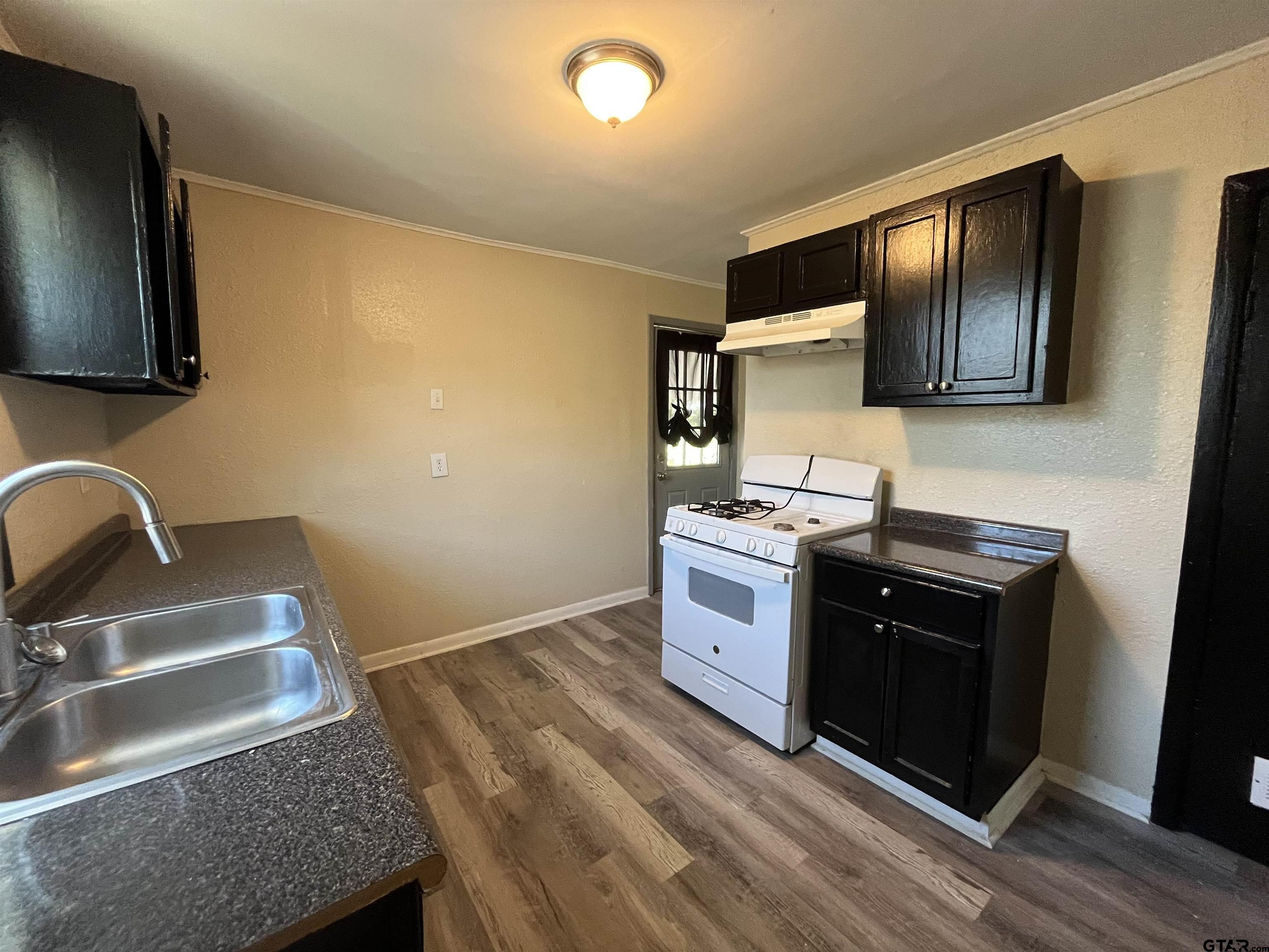 3312 North Luberta Street Tyler, TX 75702 - Photo 3 of 8 a kitchen with a stove and a sink
