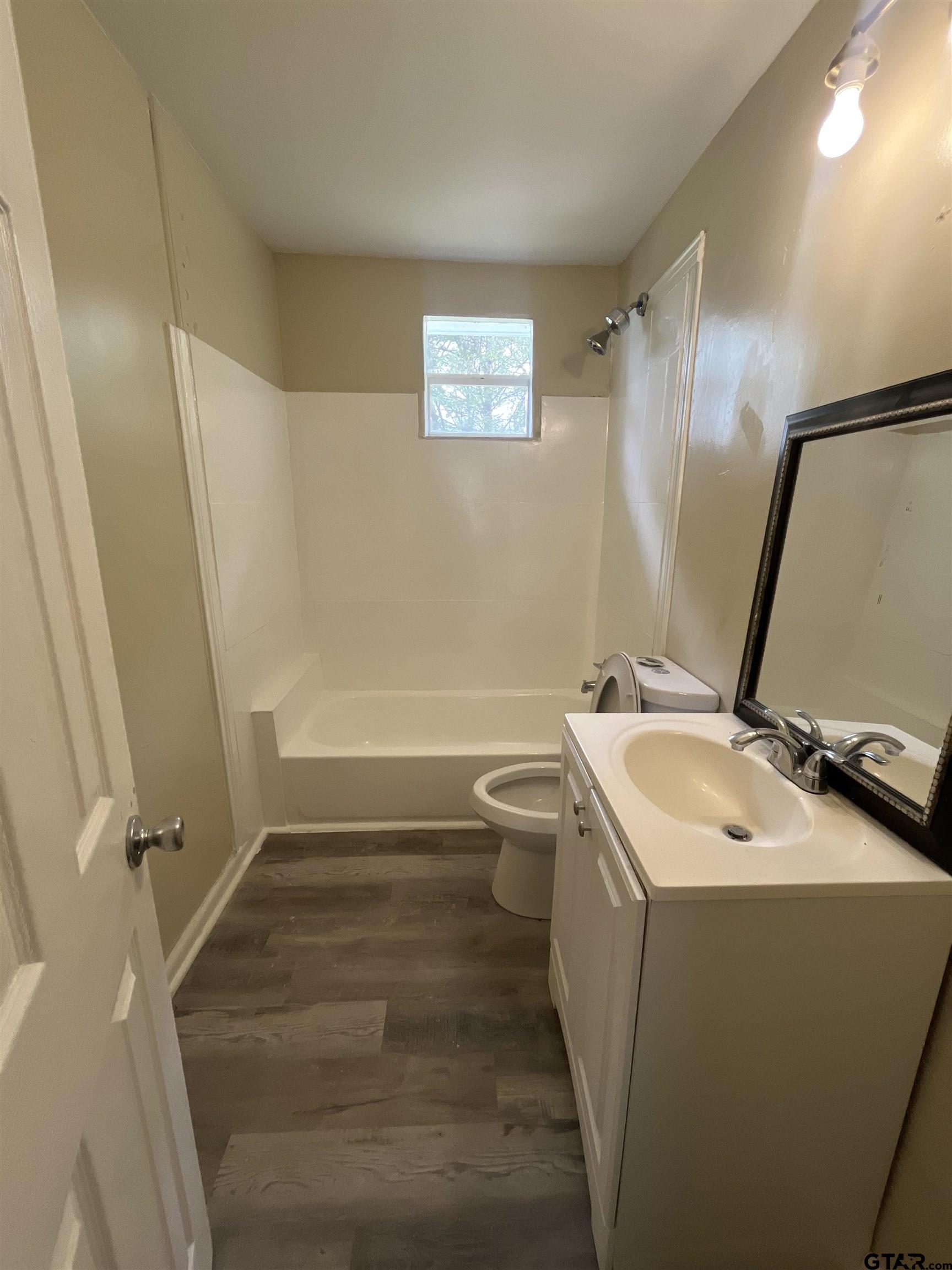 3312 North Luberta Street Tyler, TX 75702 - Photo 8 of 8 a bathroom with a sink a toilet and a mirror
